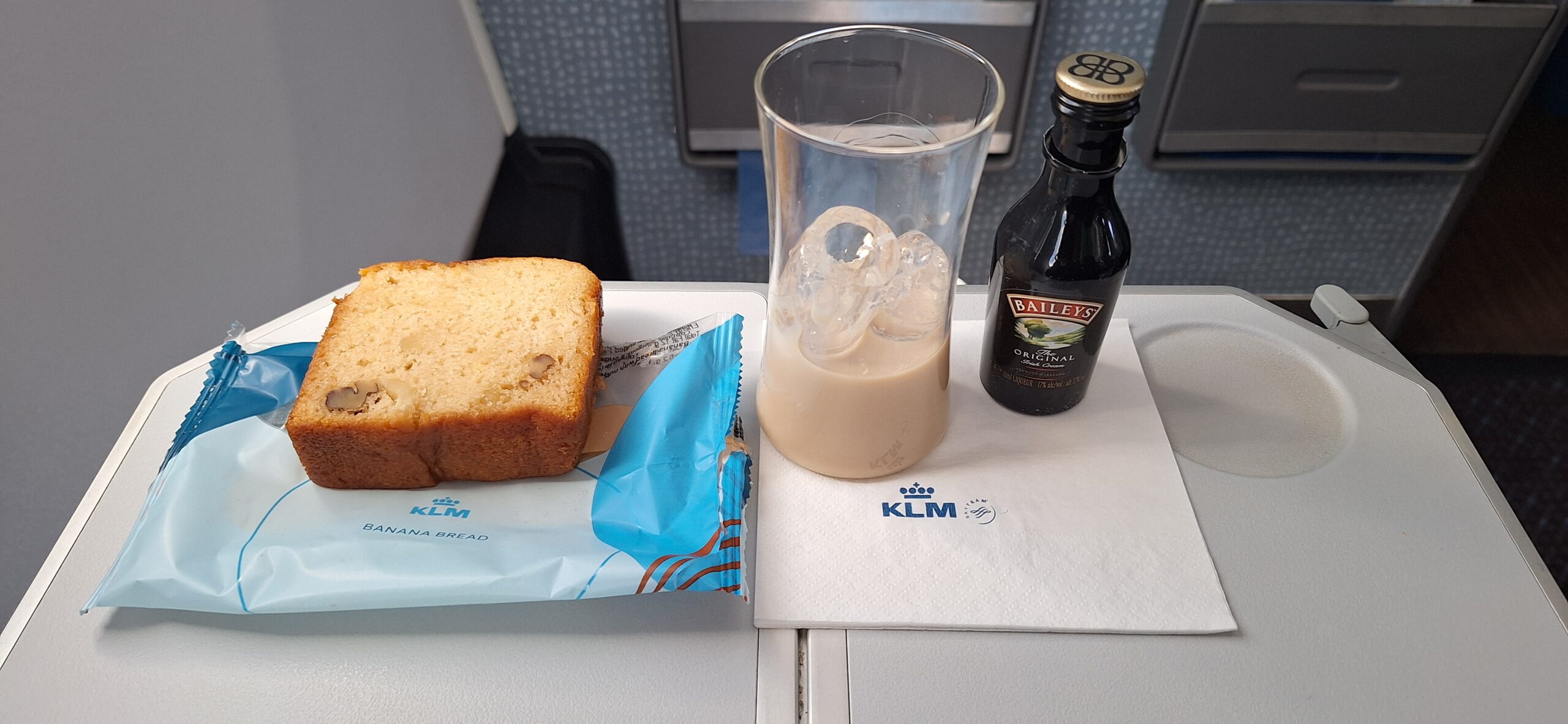 a glass of liquid and a bottle of bread on a table