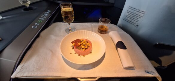 a plate of food and glasses of wine on a tray