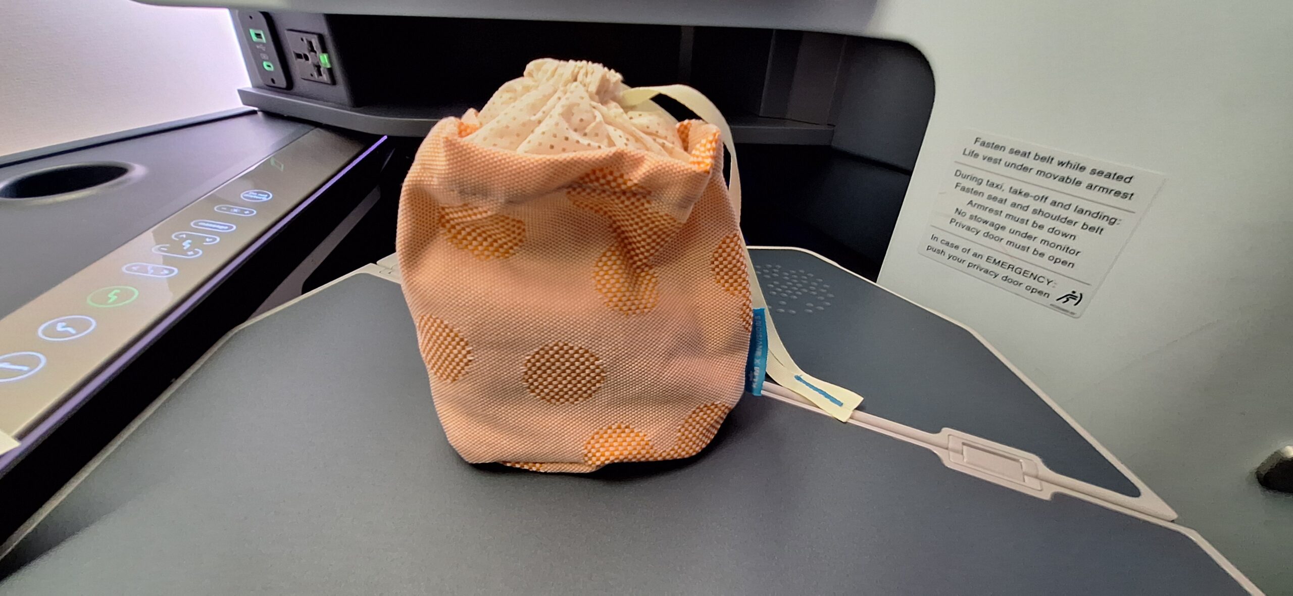 a small orange bag on a grey surface