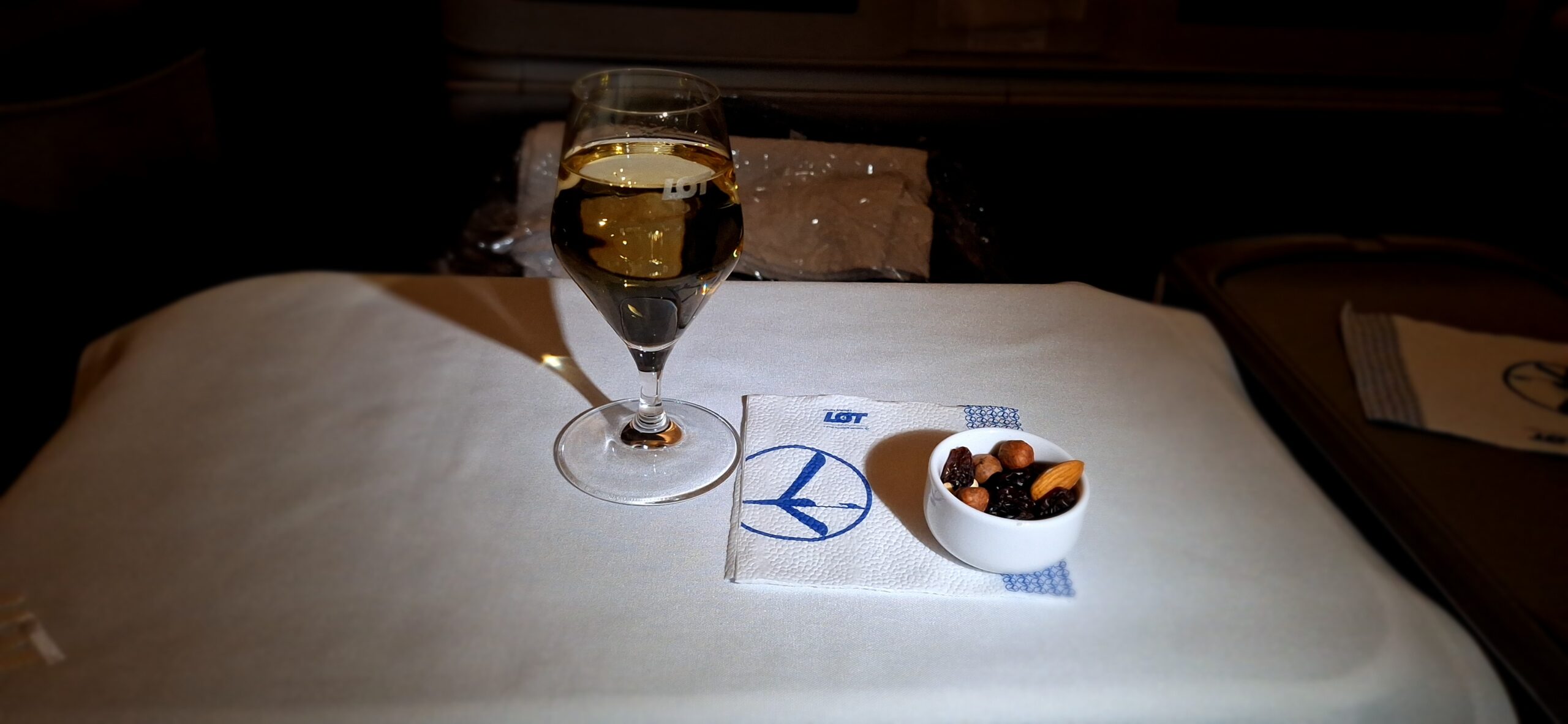 a glass of wine and a bowl of nuts