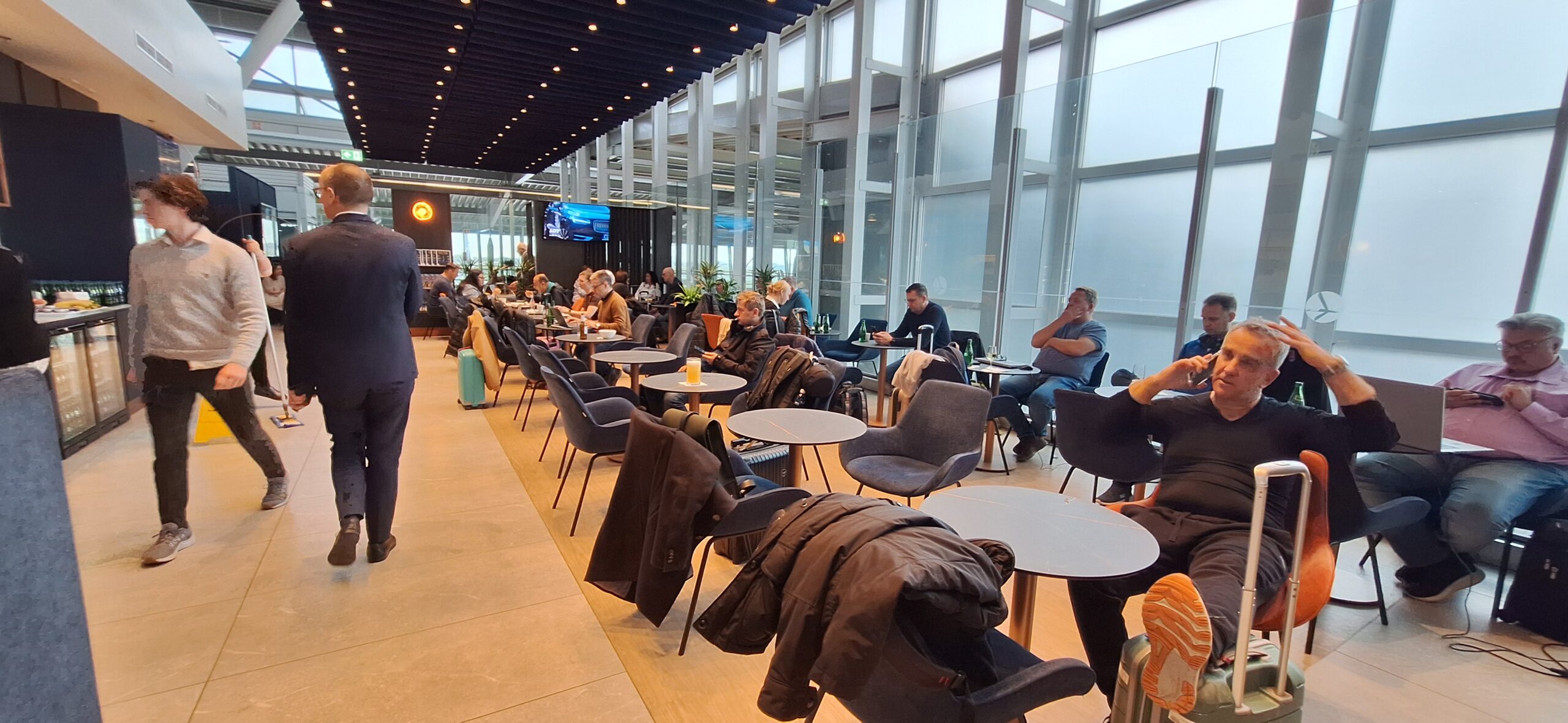 LOT Business Lounge review people sitting at tables in a room with many chairs and a large window