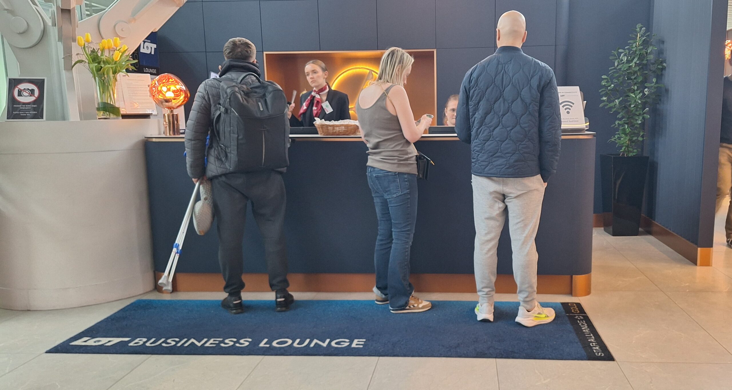 LOT Business Lounge review a group of people standing at a counter
