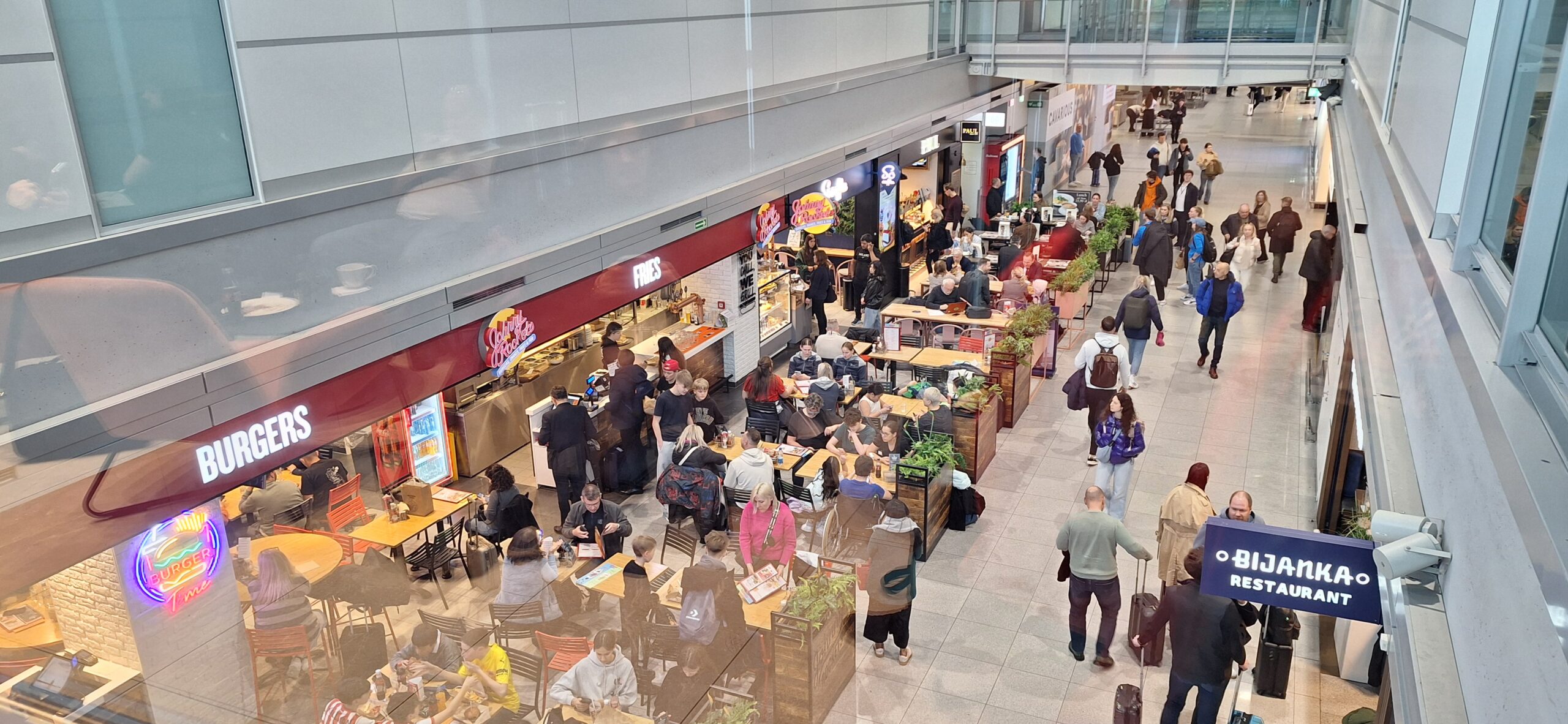 LOT Business Lounge review a group of people sitting at tables in a mall