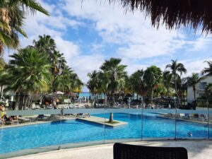 Review Viva Azteca Resort Mexico a pool with palm trees and people in the background