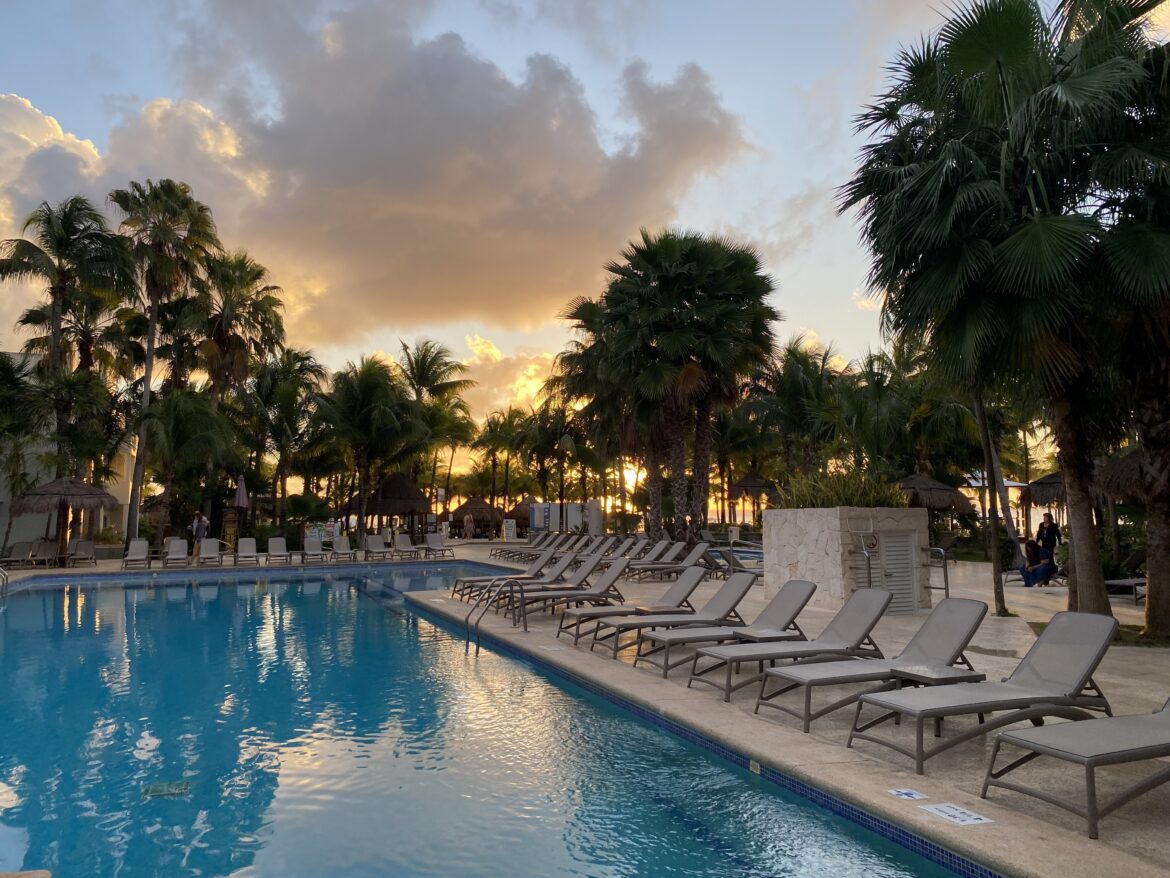 a pool with lounge chairs and palm trees