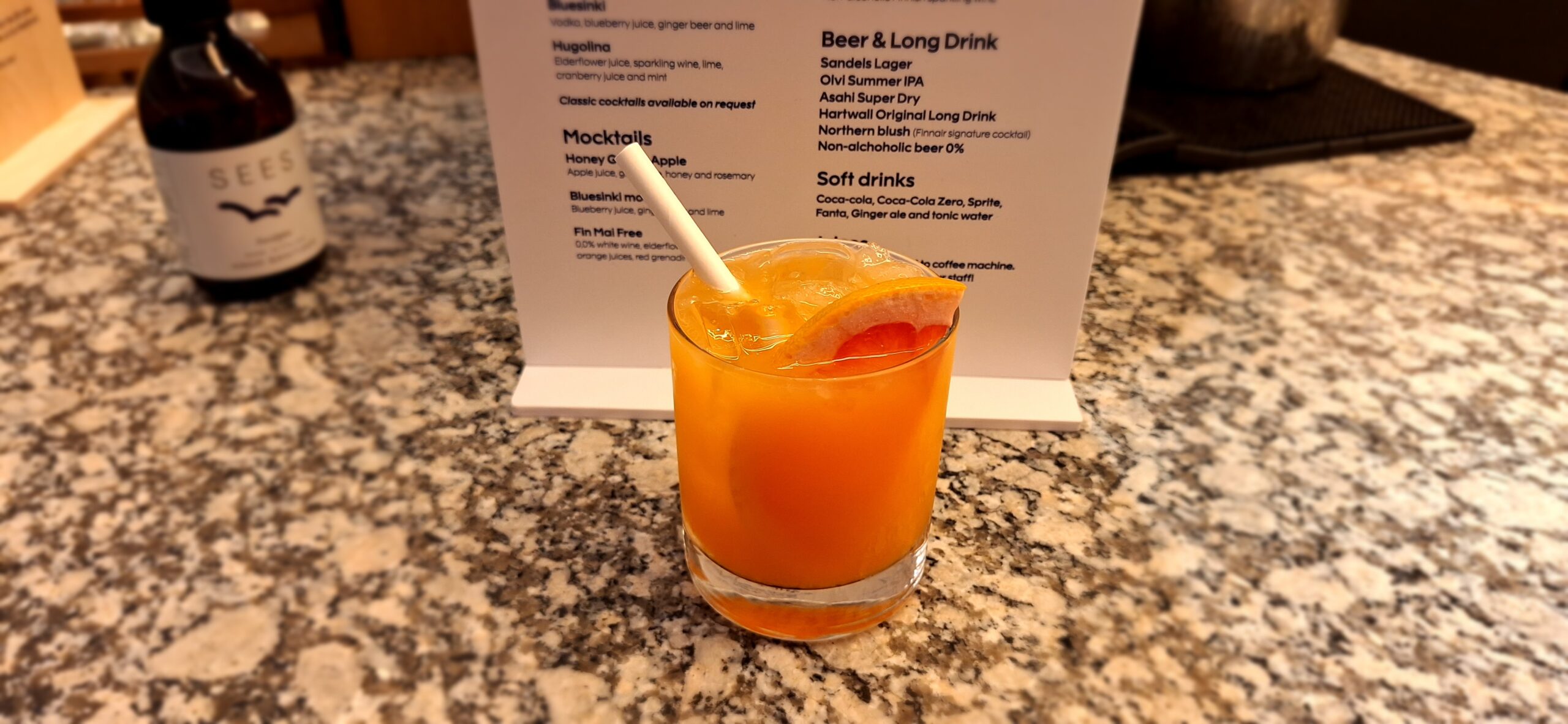 Finnair Business Class Lounge a glass of orange juice with a straw