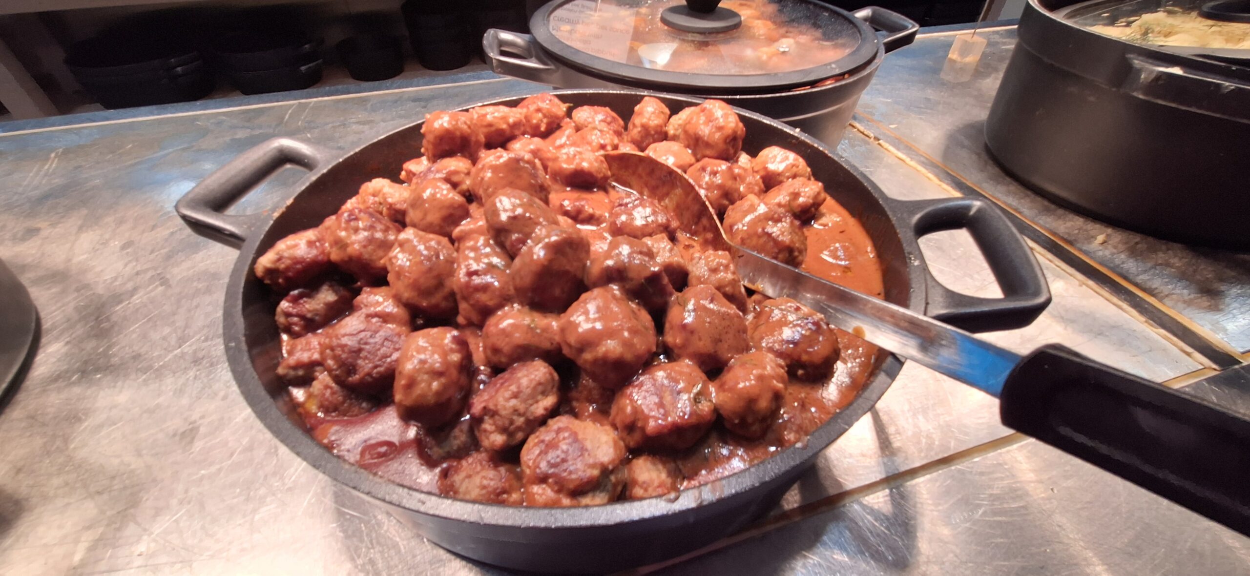 Finnair Business Class Lounge a pan of meatballs with sauce