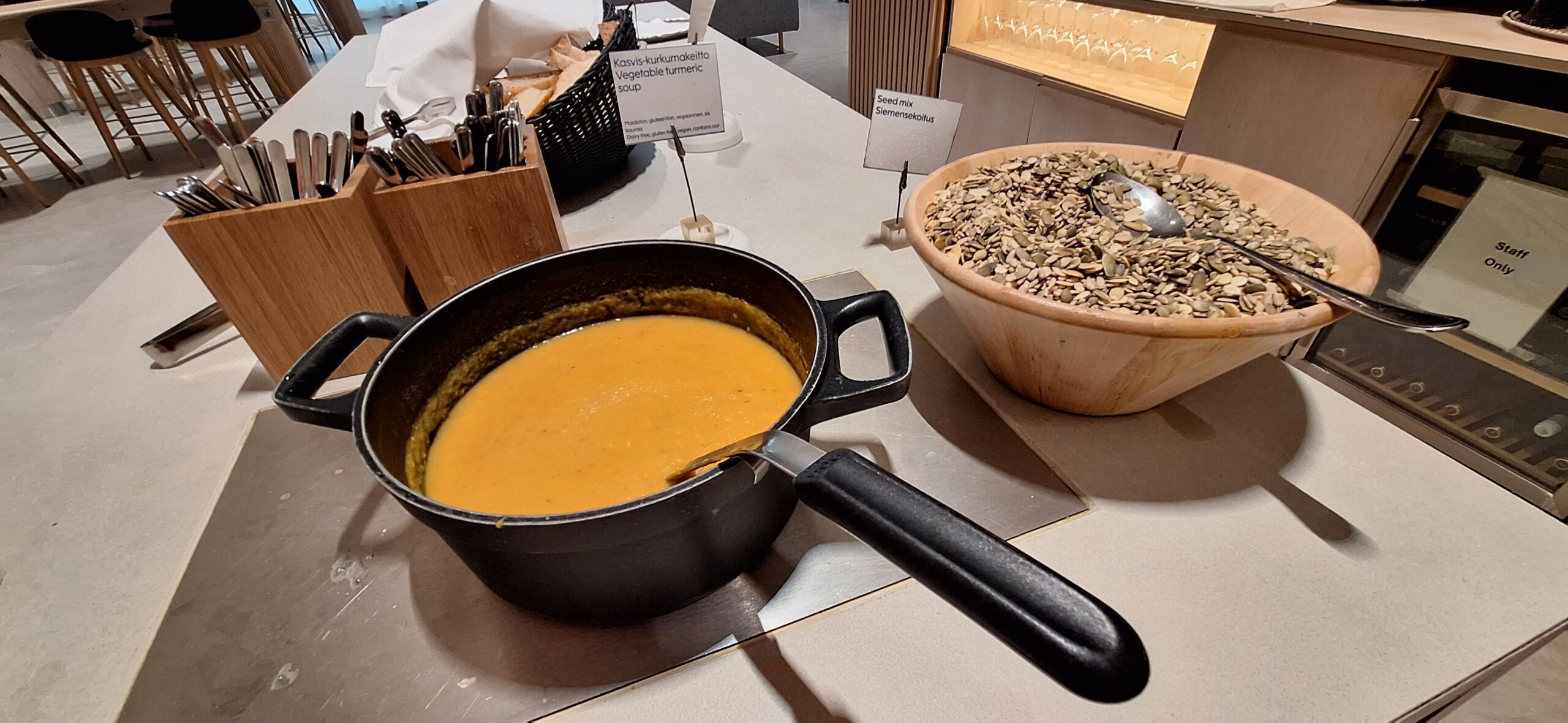 Finnair Business Class Lounge a pot of soup and a bowl of seeds