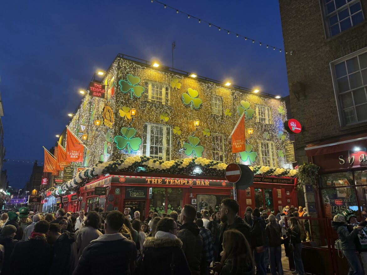 a building with lights on it and people walking around