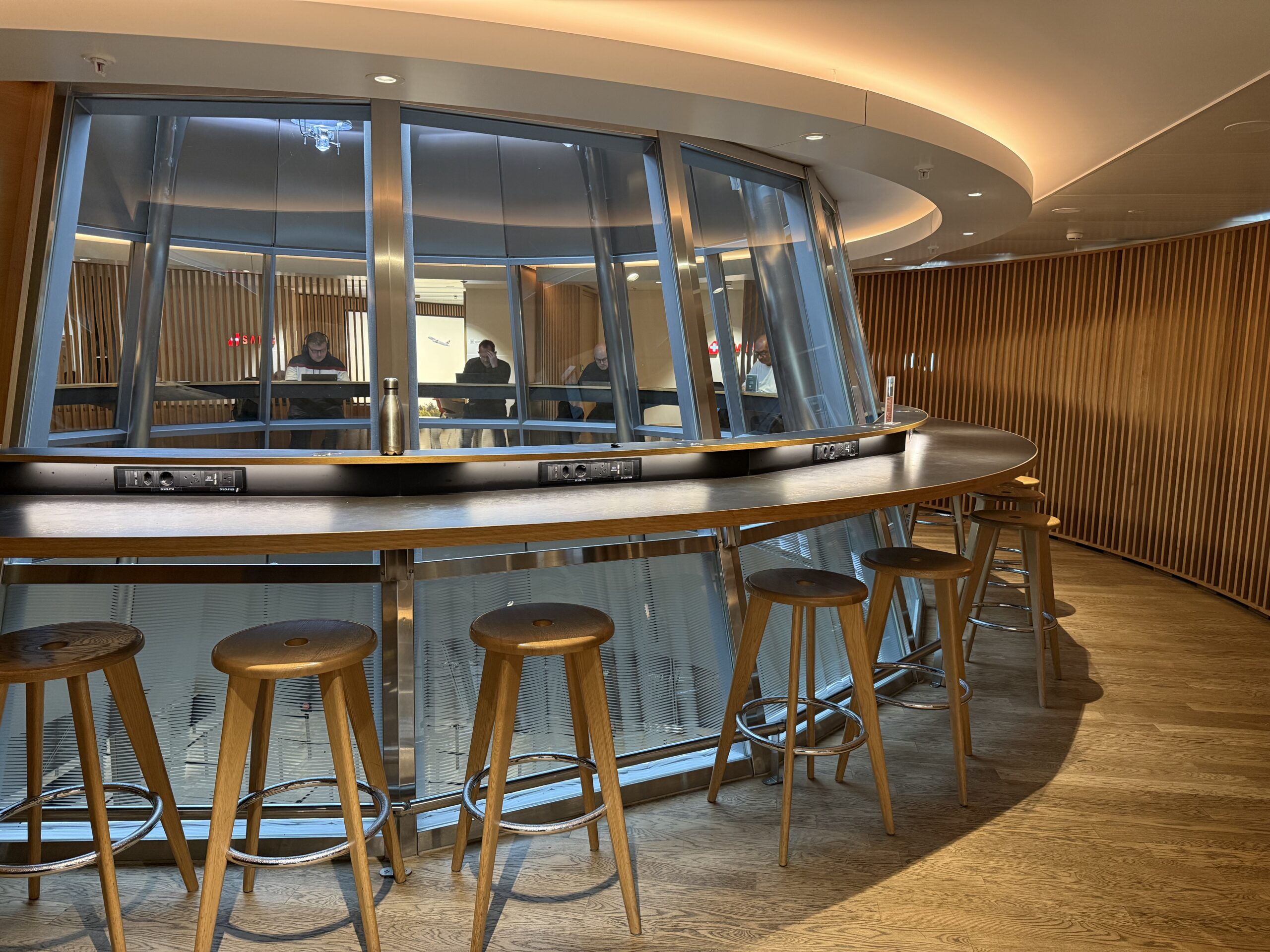 Swiss Senator Lounge Zurich Terminal A Review a round bar with stools and a round table