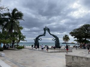 a group of people walking around a large statue