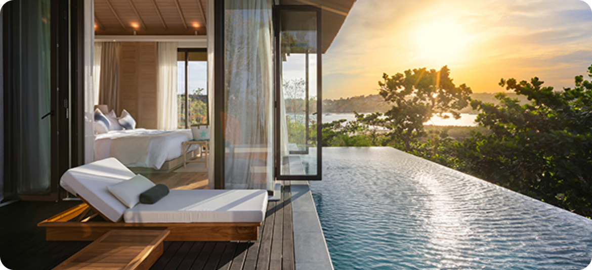 a pool with a bed and a tree in the background