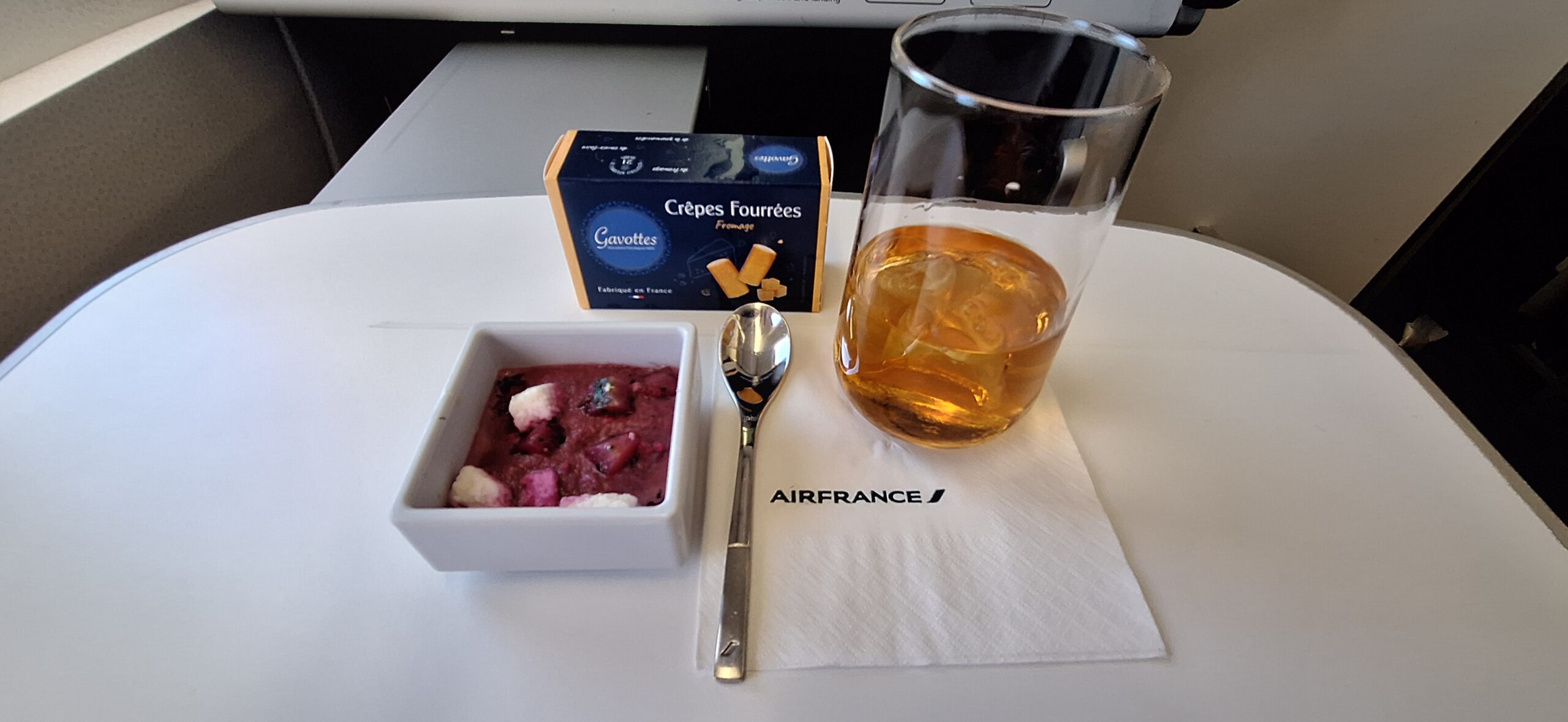 a bowl of food with a drink and a spoon on a table
