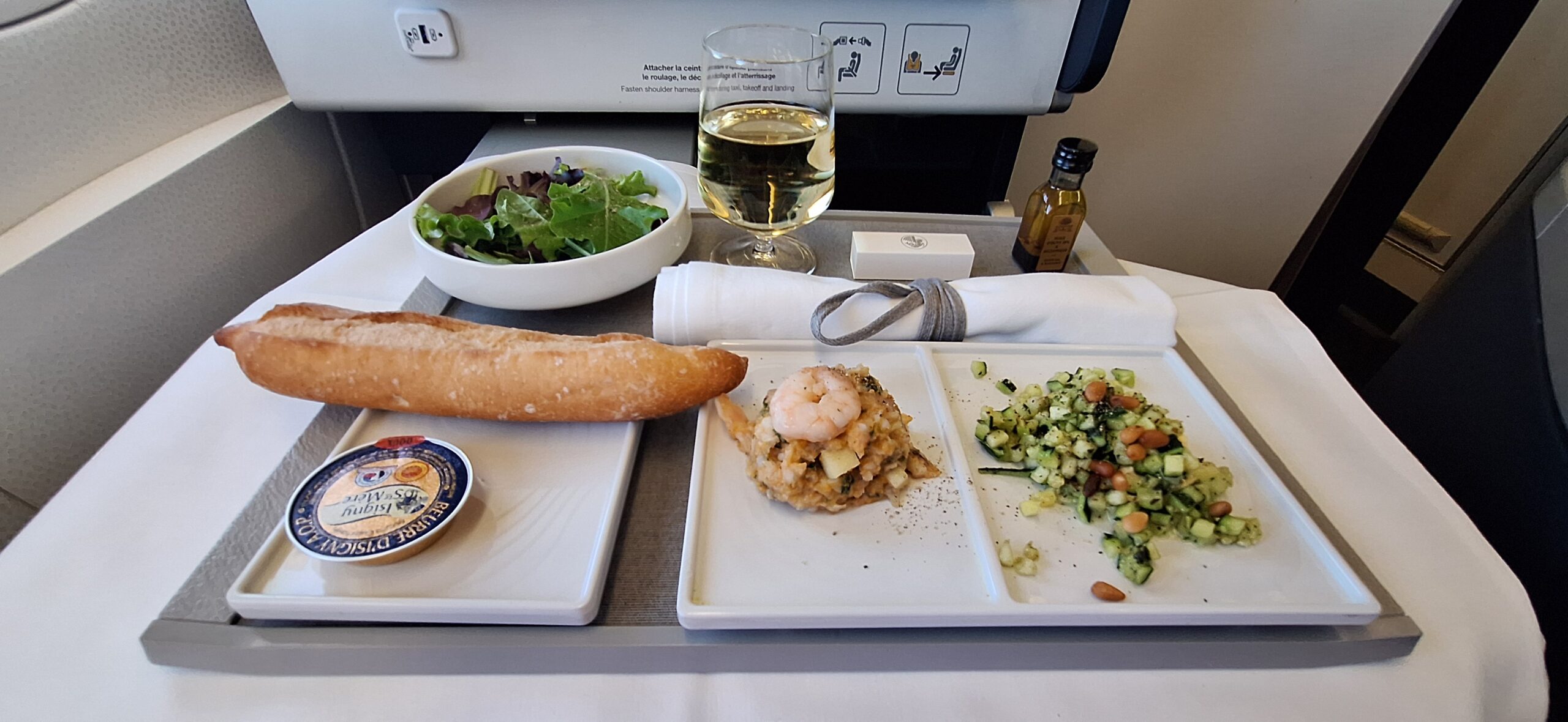 a tray with food and a glass of wine