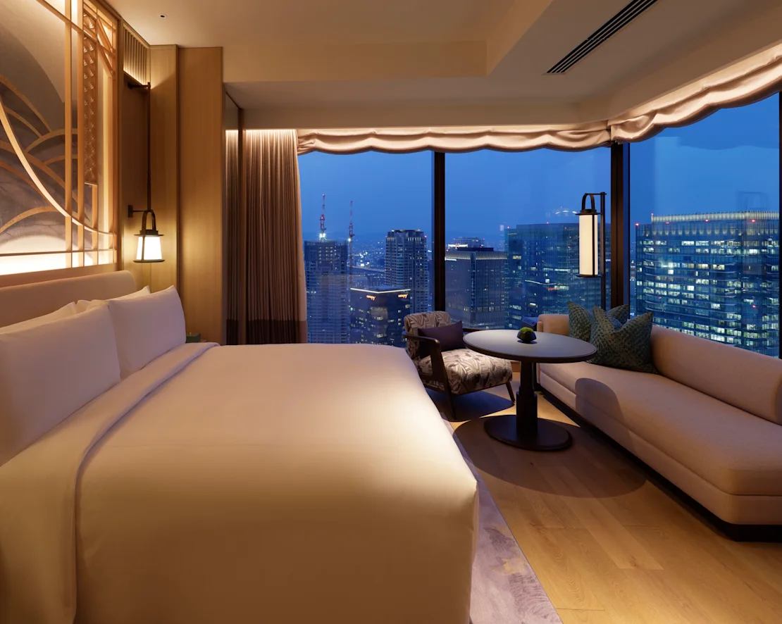 a room with a large bed and a table and chairs