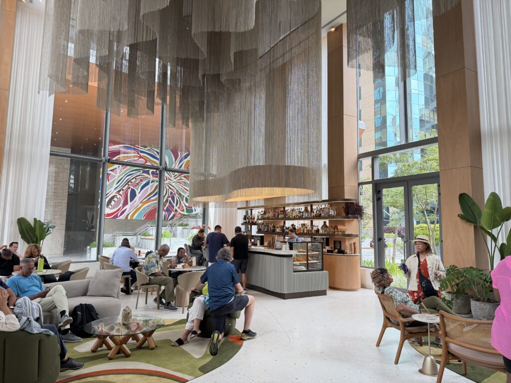 a group of people sitting in a room with a large chandelier