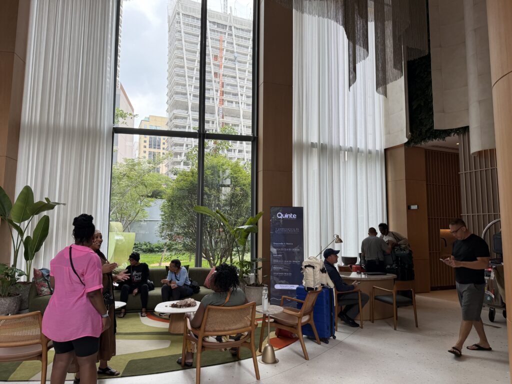 a group of people sitting in a room with large windows