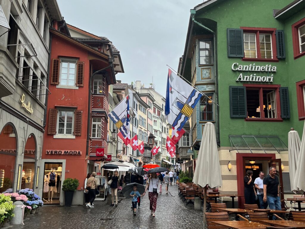 people walking down a street with flags and people