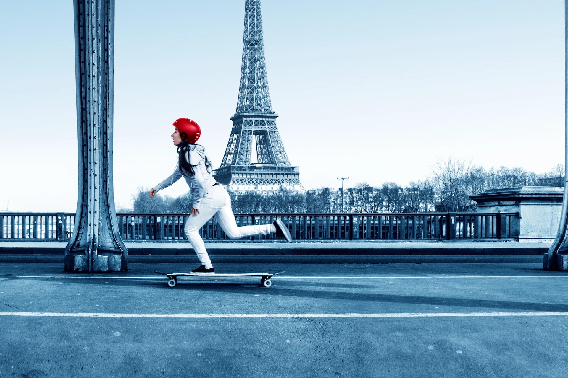 a woman riding a skateboard in front of a tower
