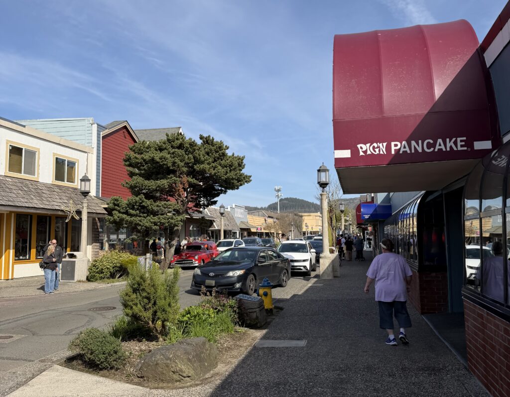 a street with cars and people walking on it