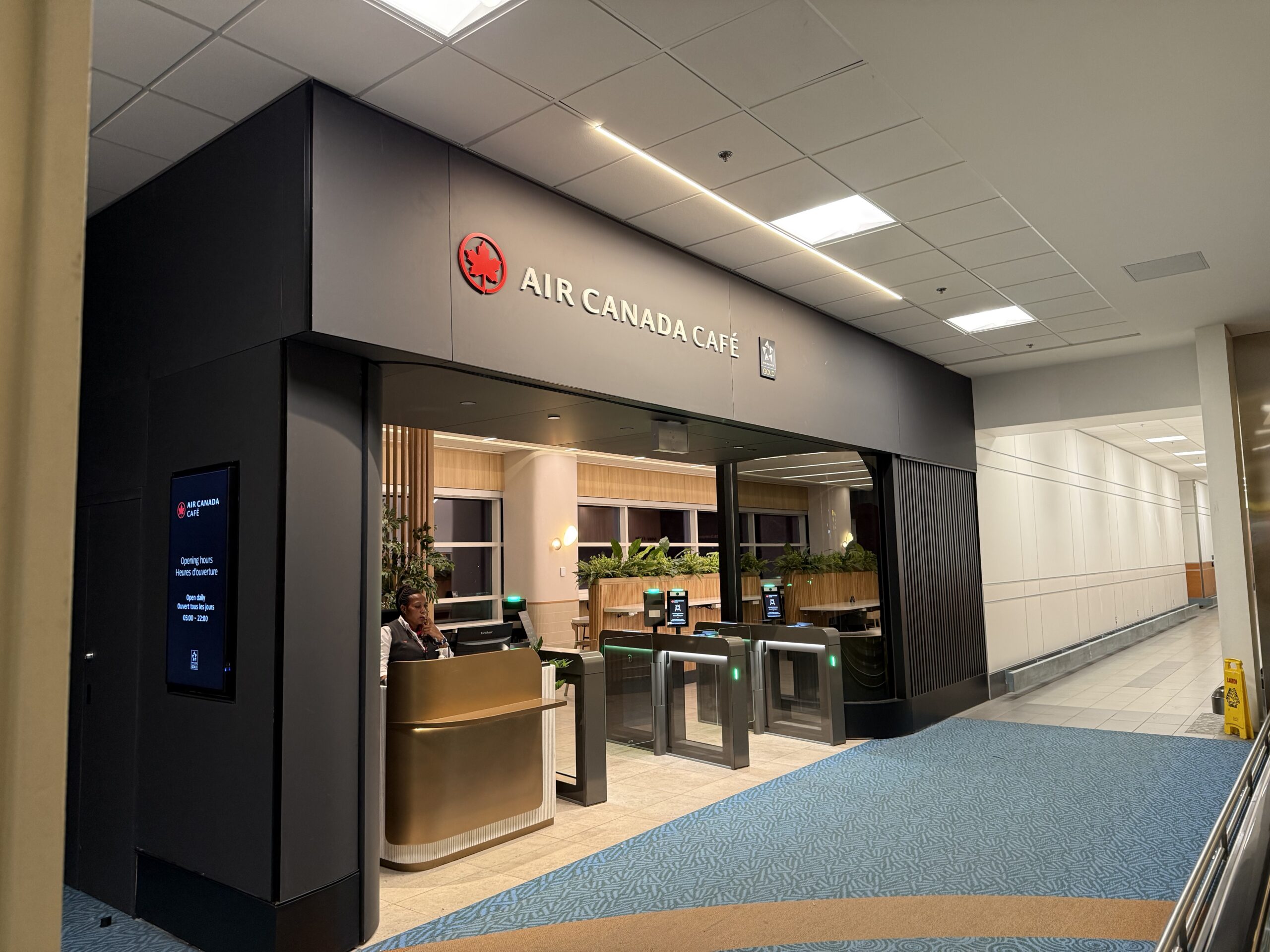 Air Canada Cafe YVR C47 a building with a sign and a man standing in front of it