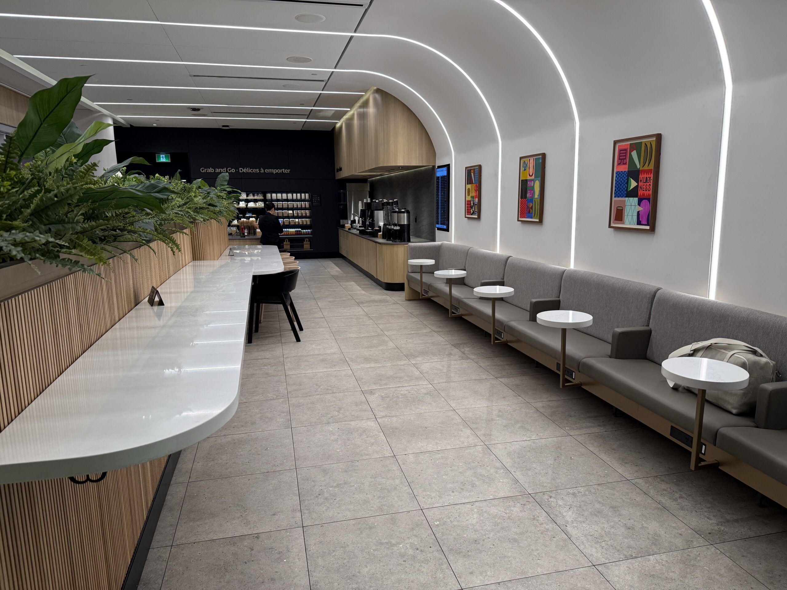 Air Canada Cafe YVR C47 a room with white walls and a white counter with tables and chairs