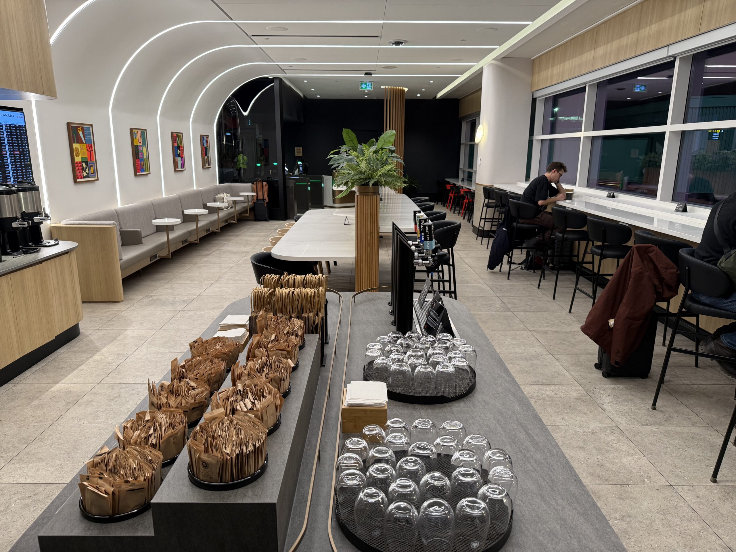Air Canada Cafe YVR C47 a room with a table and chairs and a man sitting at a table