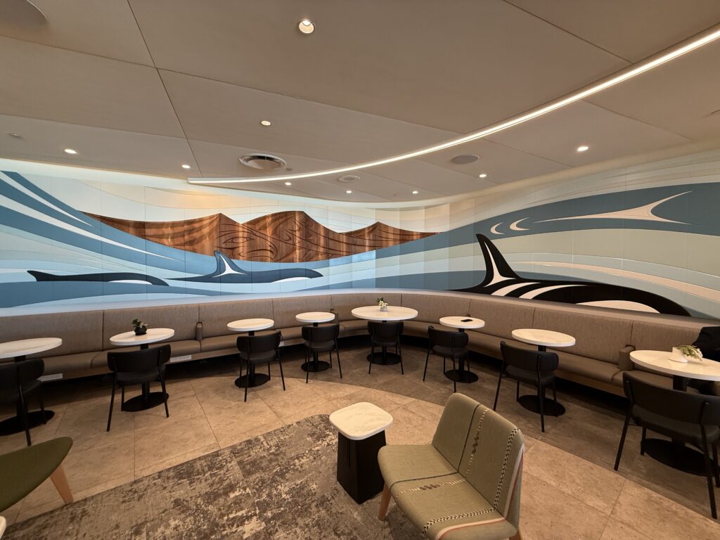 Air Canada Cafe YVR C50 a room with a wall mural and tables and chairs