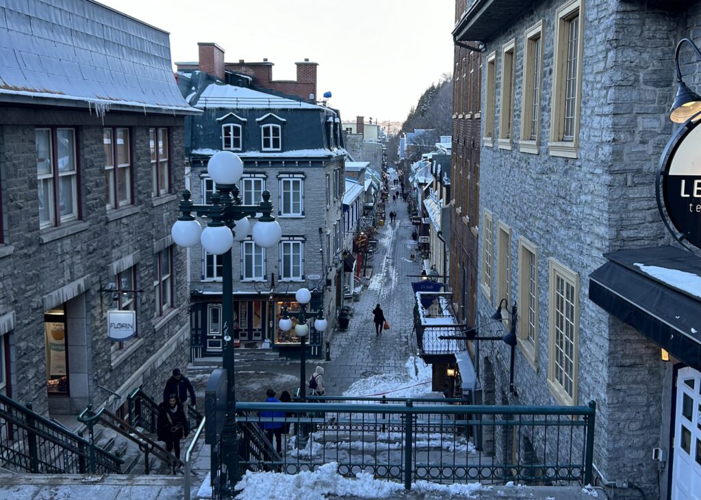 a street with stairs and people walking down it
