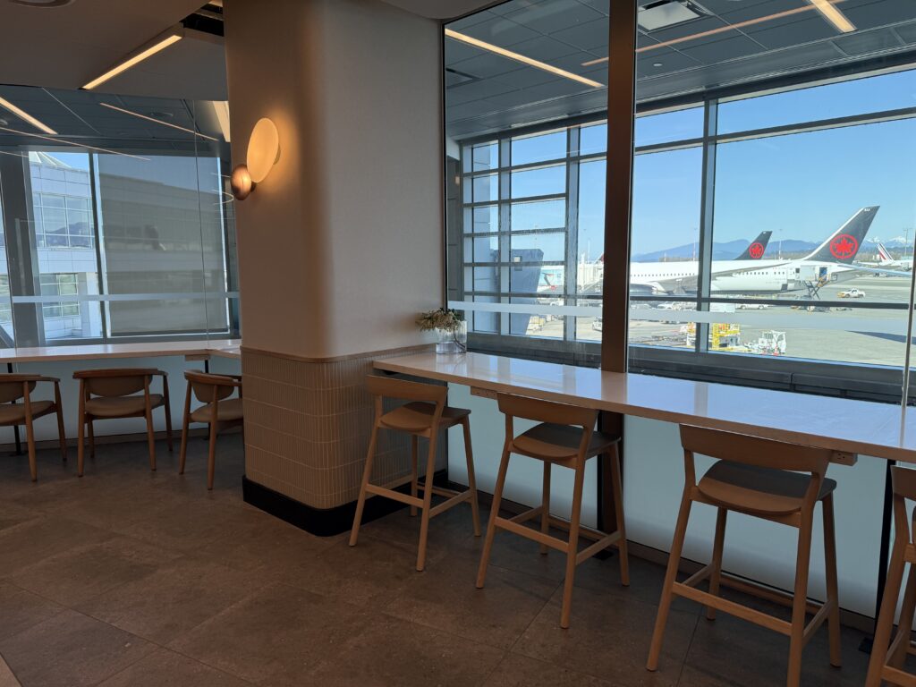 Air Canada Cafe YVR C50 a room with a window and chairs and tables