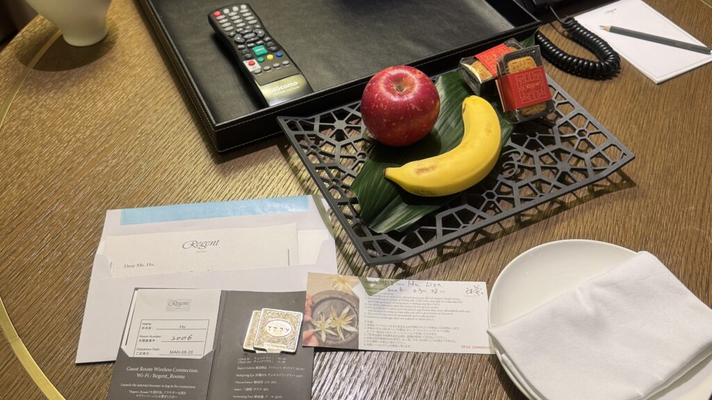 a table with a remote control and fruit on it