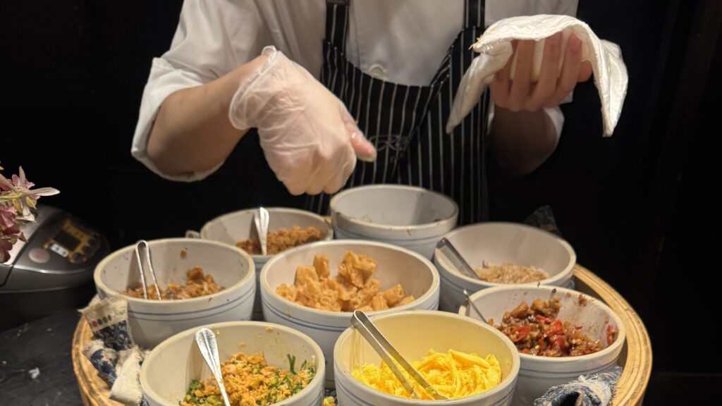 a person wearing gloves and holding a napkin in front of bowls of food