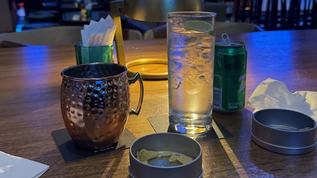 a glass of water and a can of soda on a table