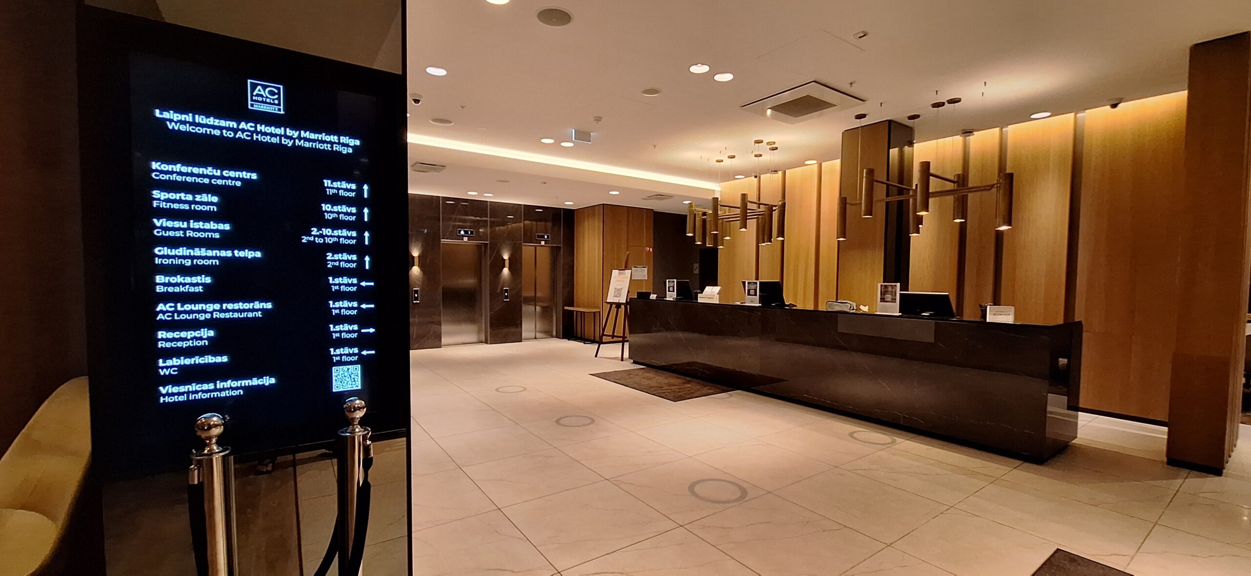 AC Hotel Riga by Marriott Review a lobby with a reception desk and elevator