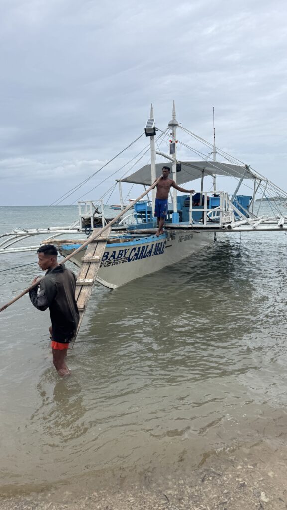 two men standing on a boat in the water