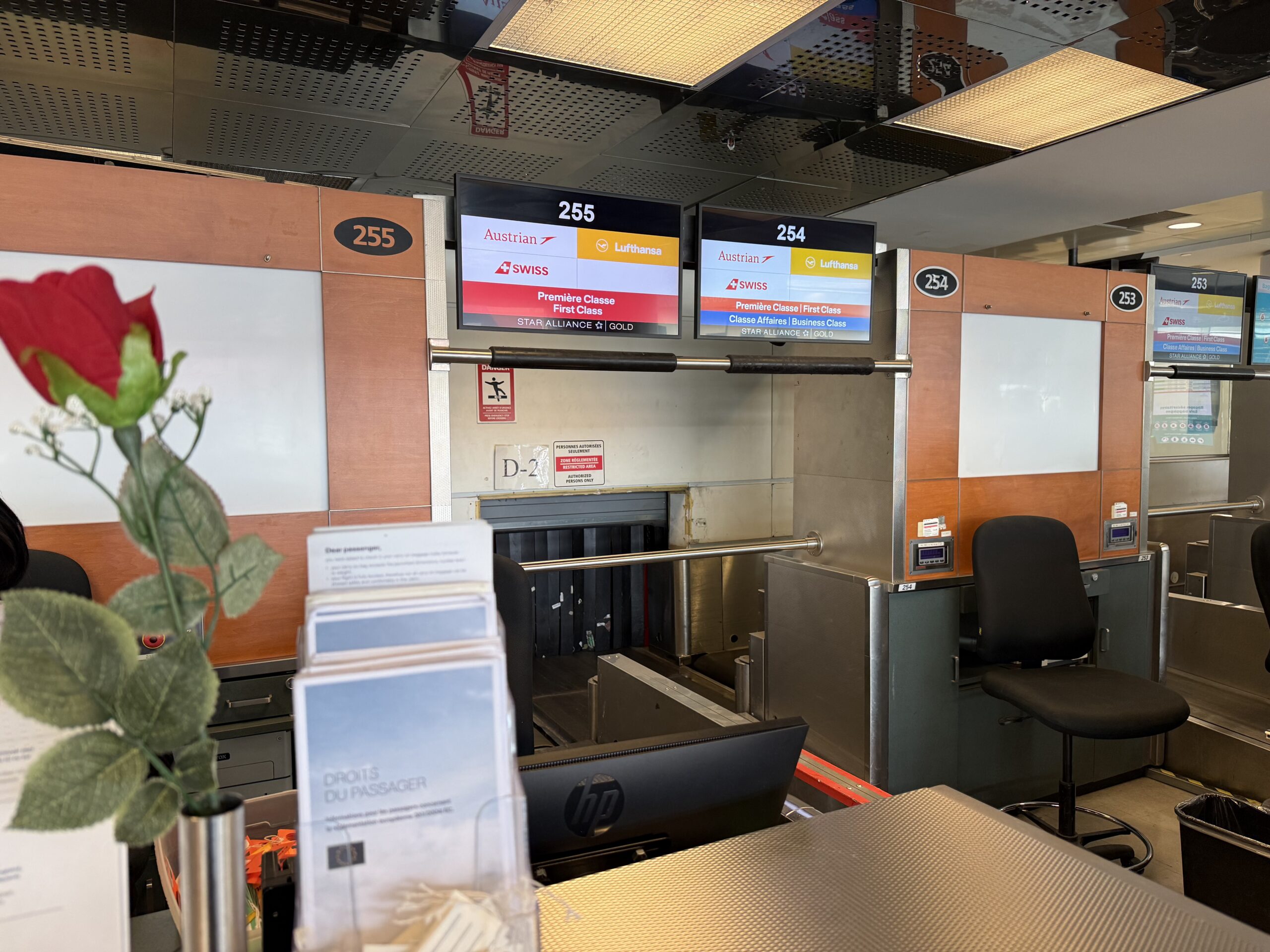 a check in counter with signs and a flower