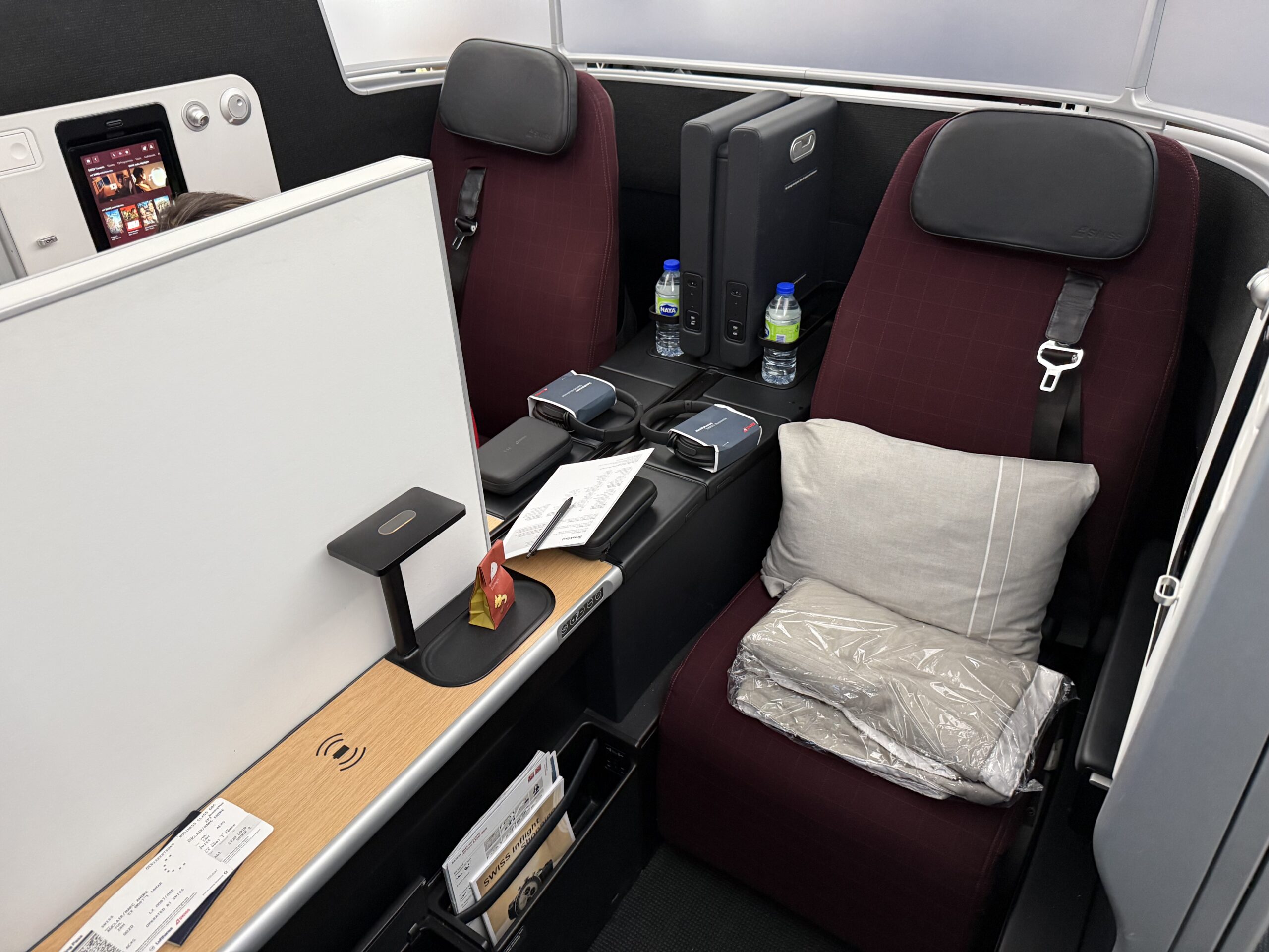 a seat with a pillow and a white board on the side