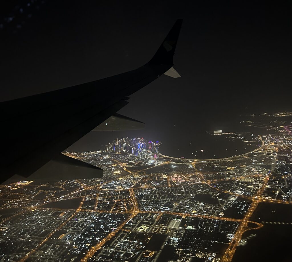 an airplane wing and city lights at night