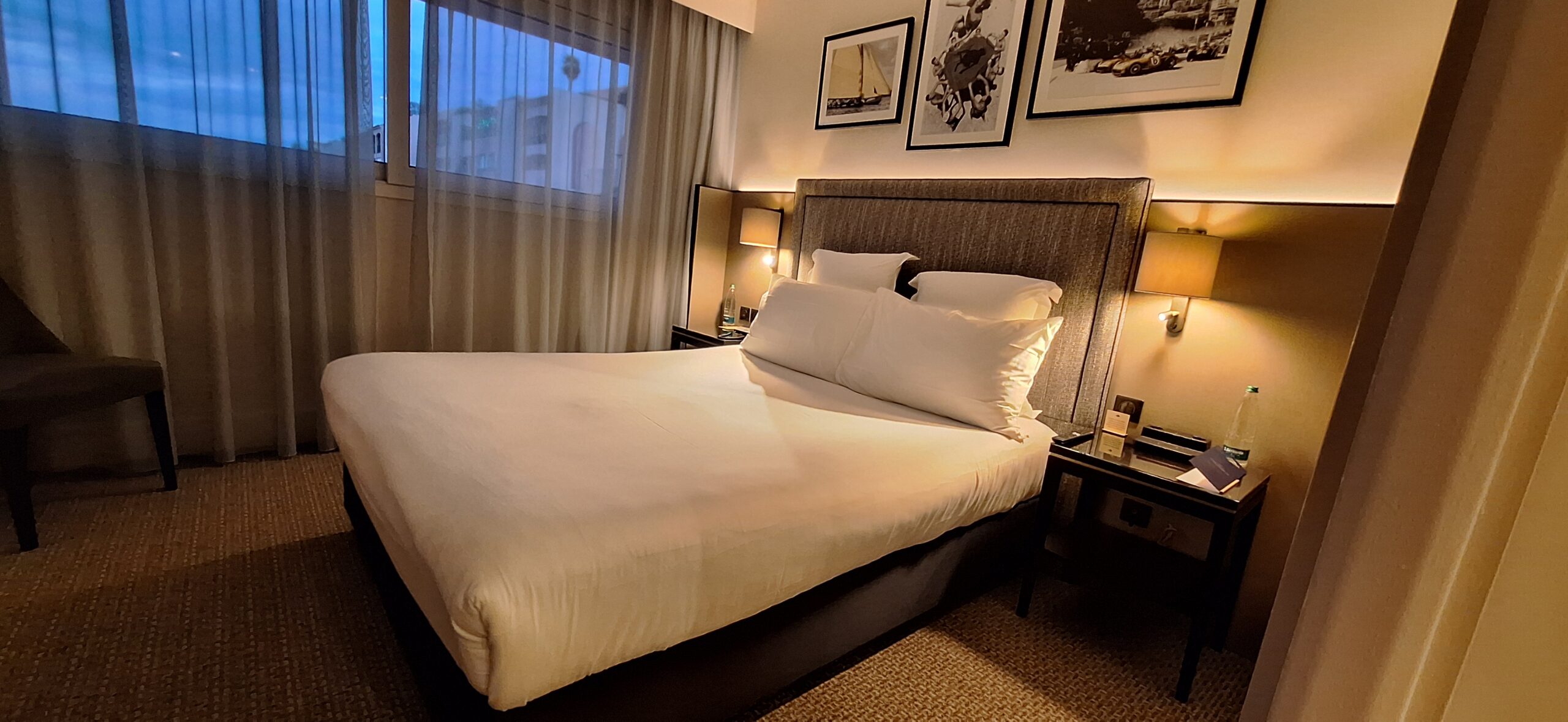 a bed with white sheets and pillows