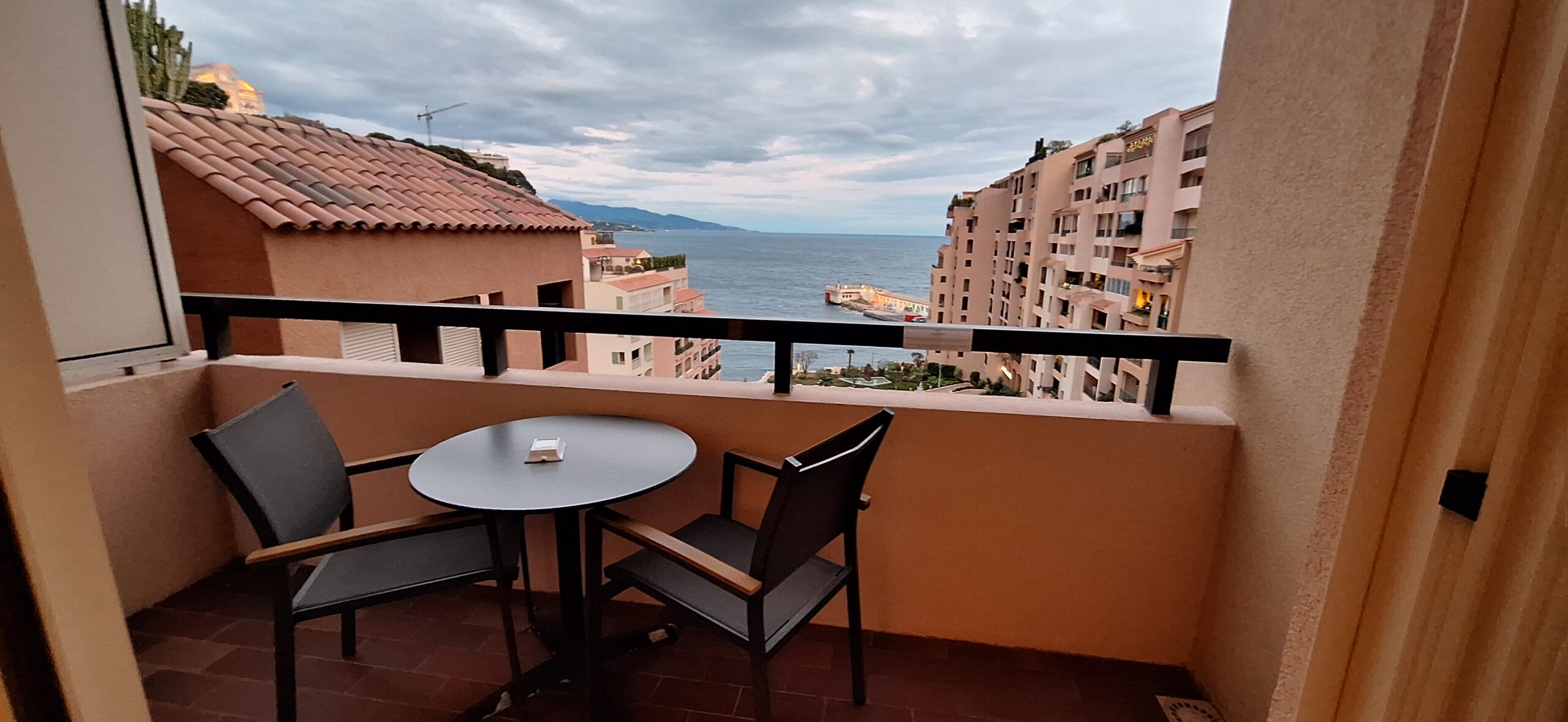 a table and chair on a balcony overlooking a body of water
