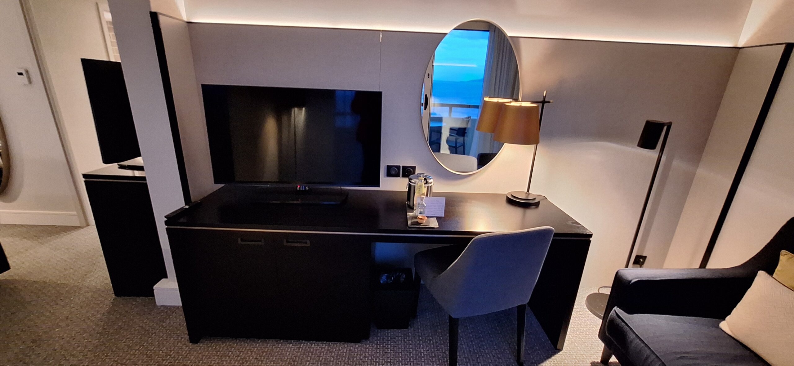 a desk with a mirror and a television