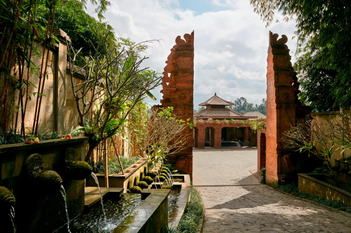 a brick archway with water fountain and a building
