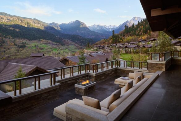 a patio with a fire pit and mountains in the background
