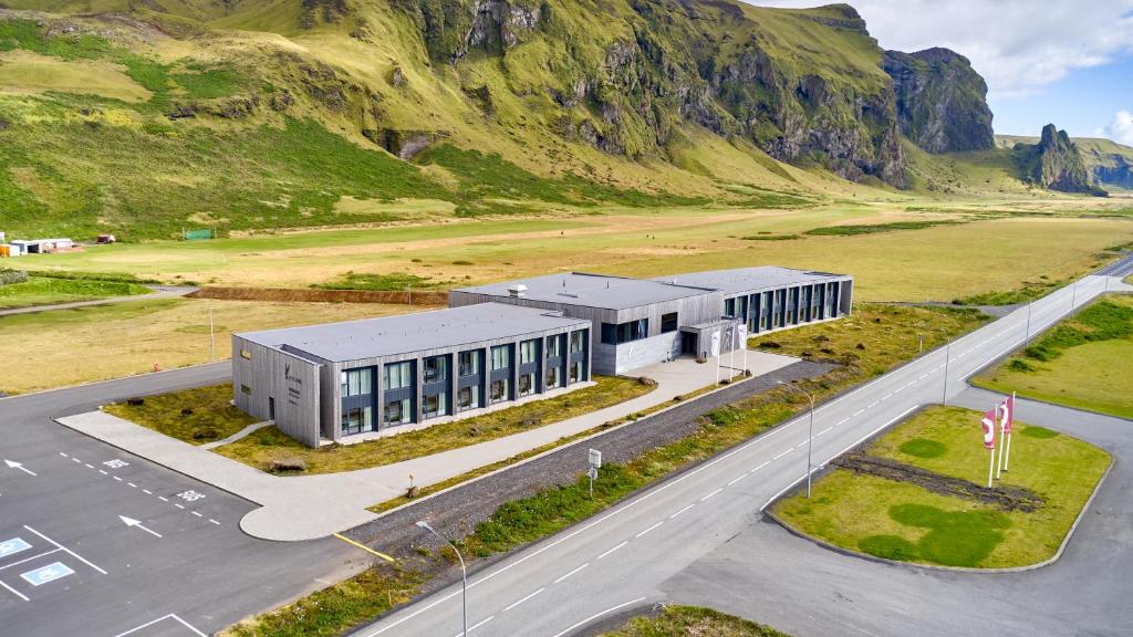 a building with a road and mountains in the background