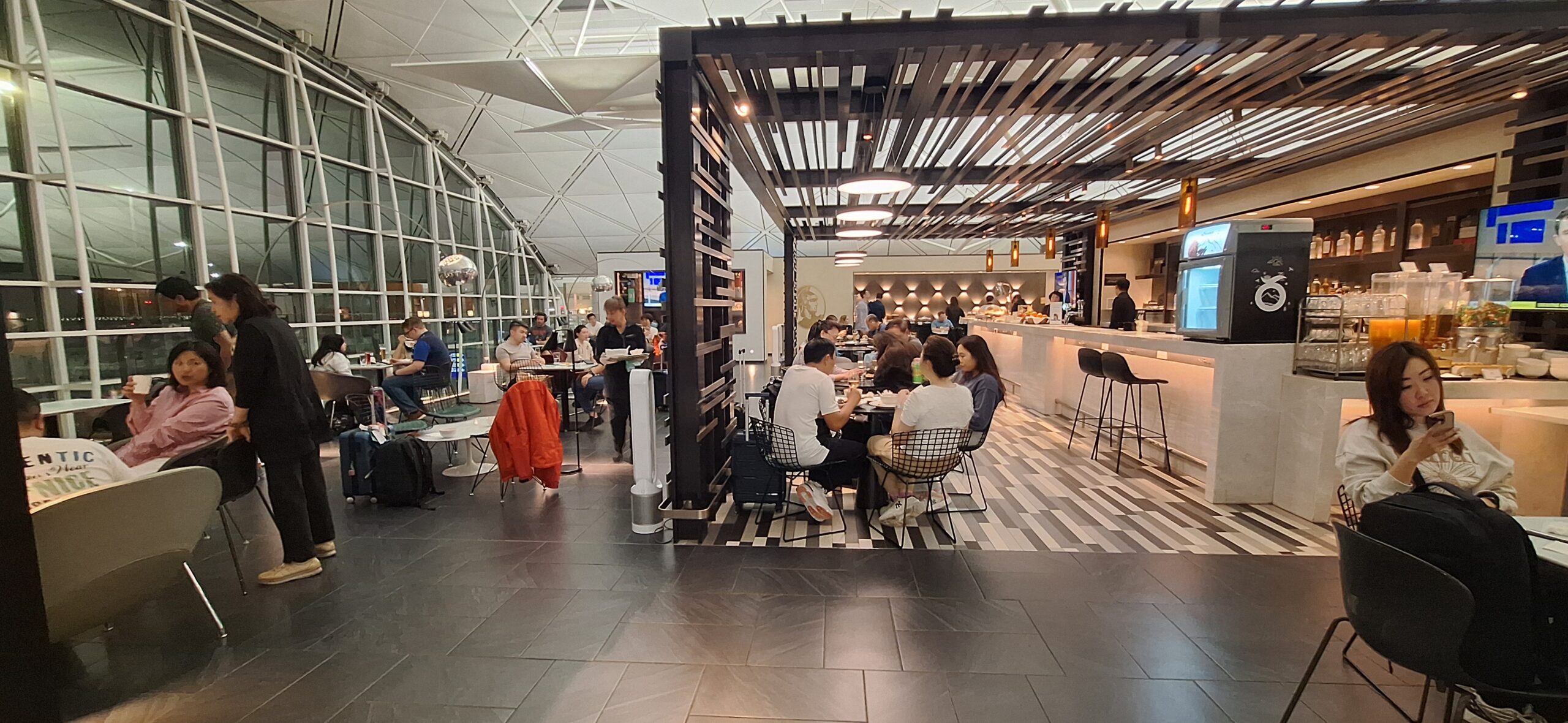 Centurion Lounge Hong Kong people sitting at tables in a room with people eating