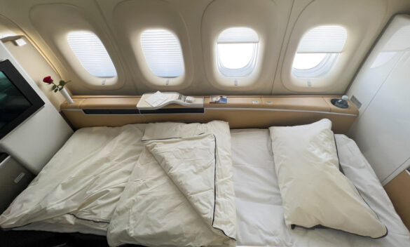 a bed with white sheets and pillows on a plane