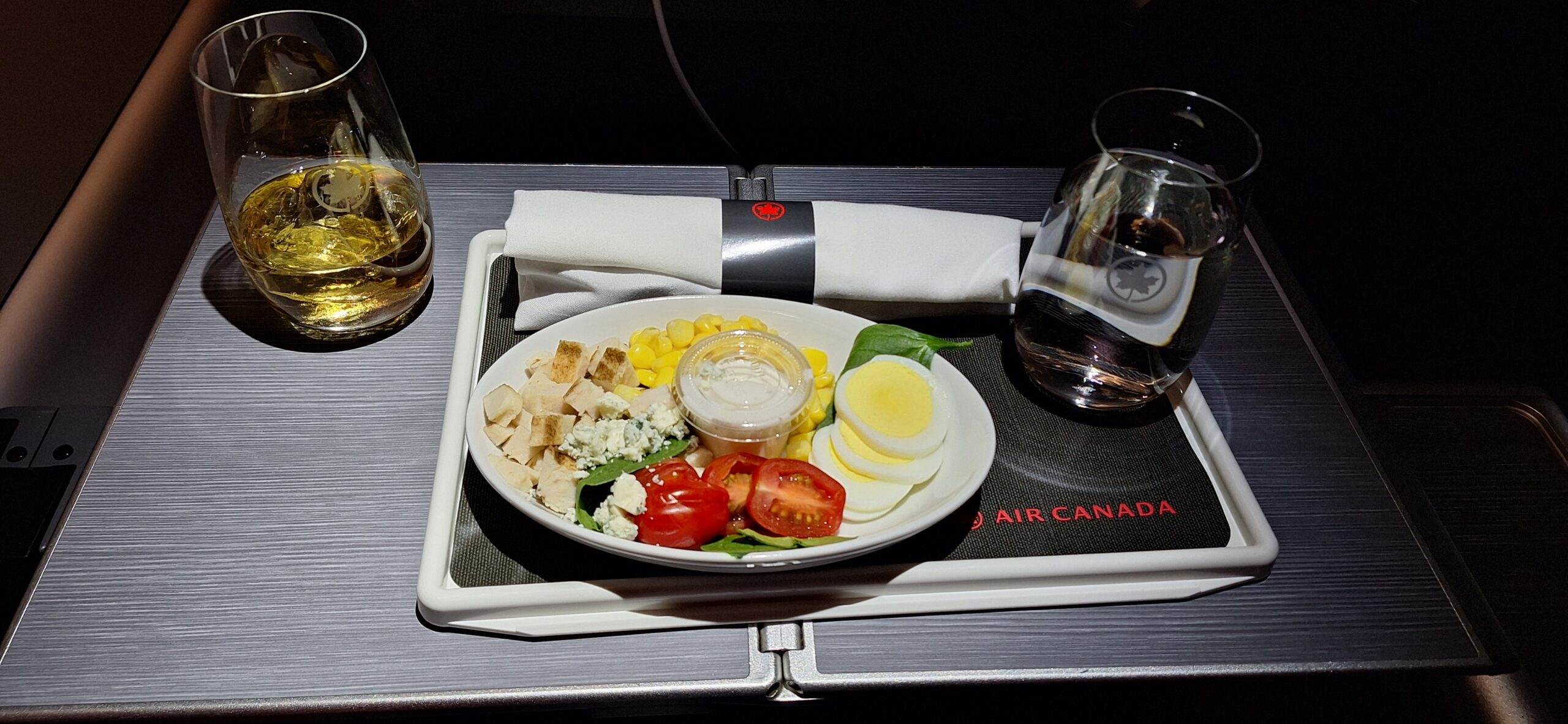 EVA Air Business Class a plate of salad and a glass of water on a tray