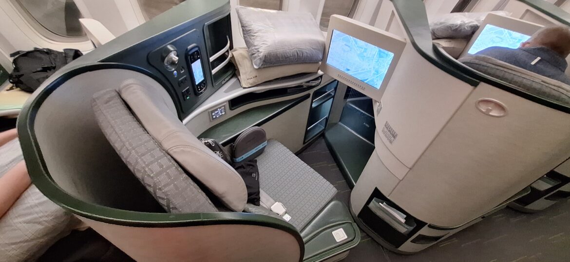 a seat with a monitor and pillows on it