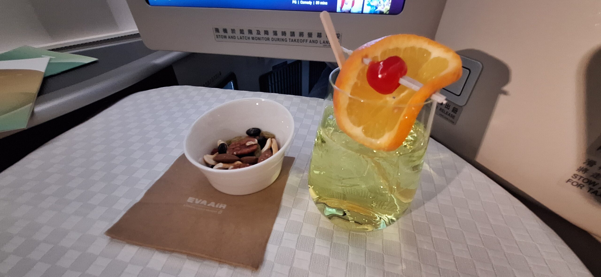 EVA Air Business Class a glass of drink with a cherry and a bowl of nuts