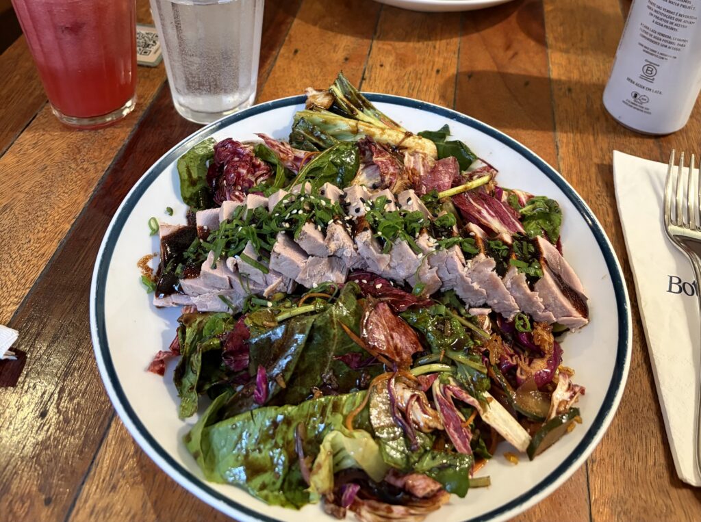 a plate of salad with meat and vegetables